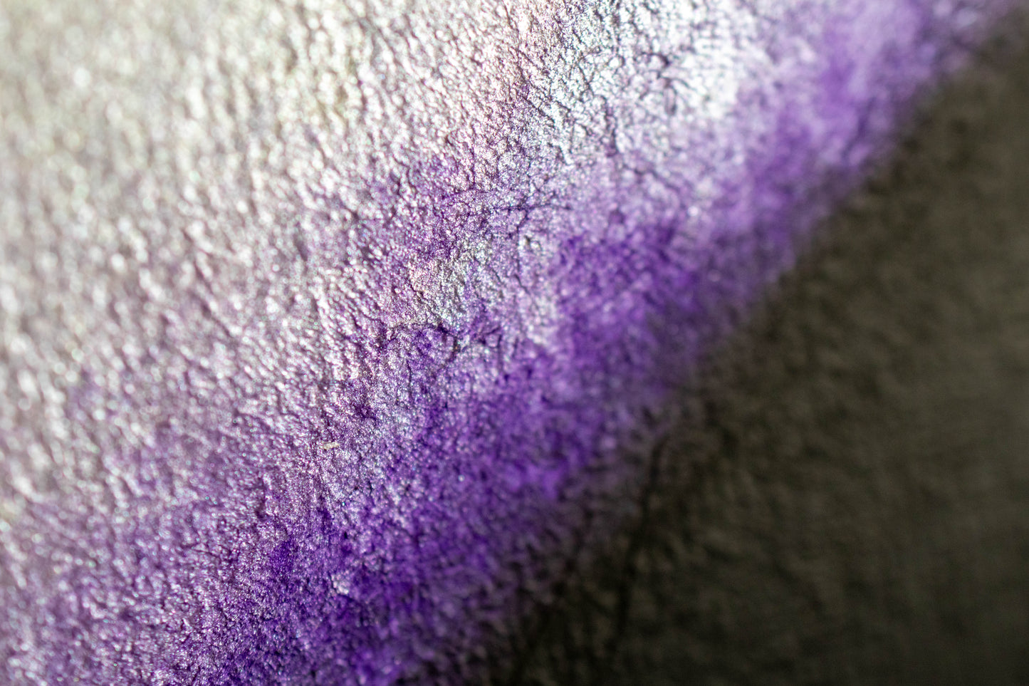 The Evolution of Her Founder's Edition: close-up of iridescent purple, cracked metallic texture with silver highlights.