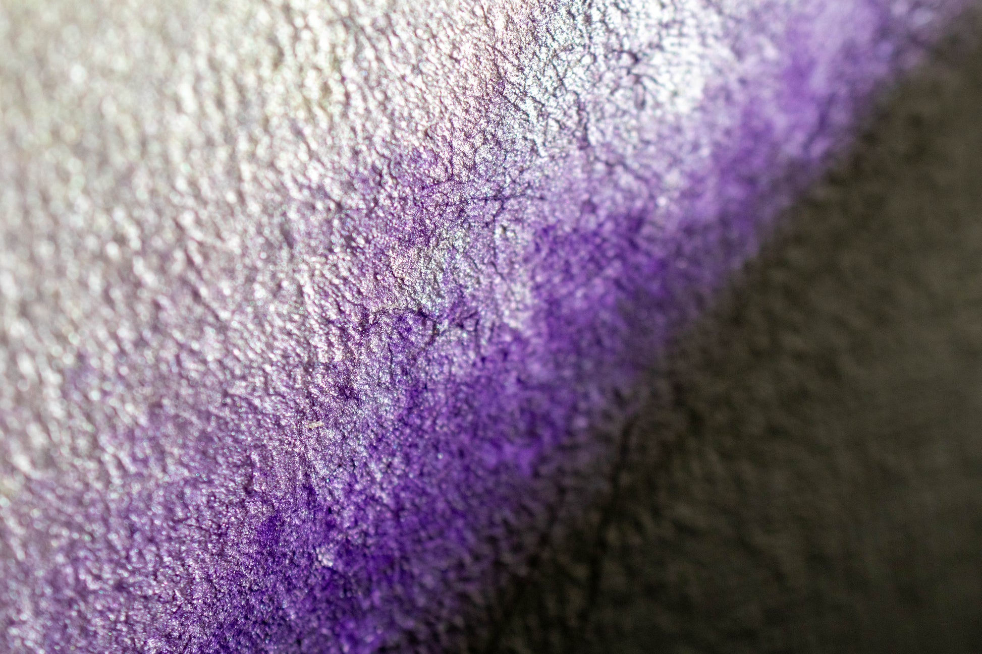 The Evolution of Her Founder's Edition: close-up of iridescent purple, cracked metallic texture with silver highlights.